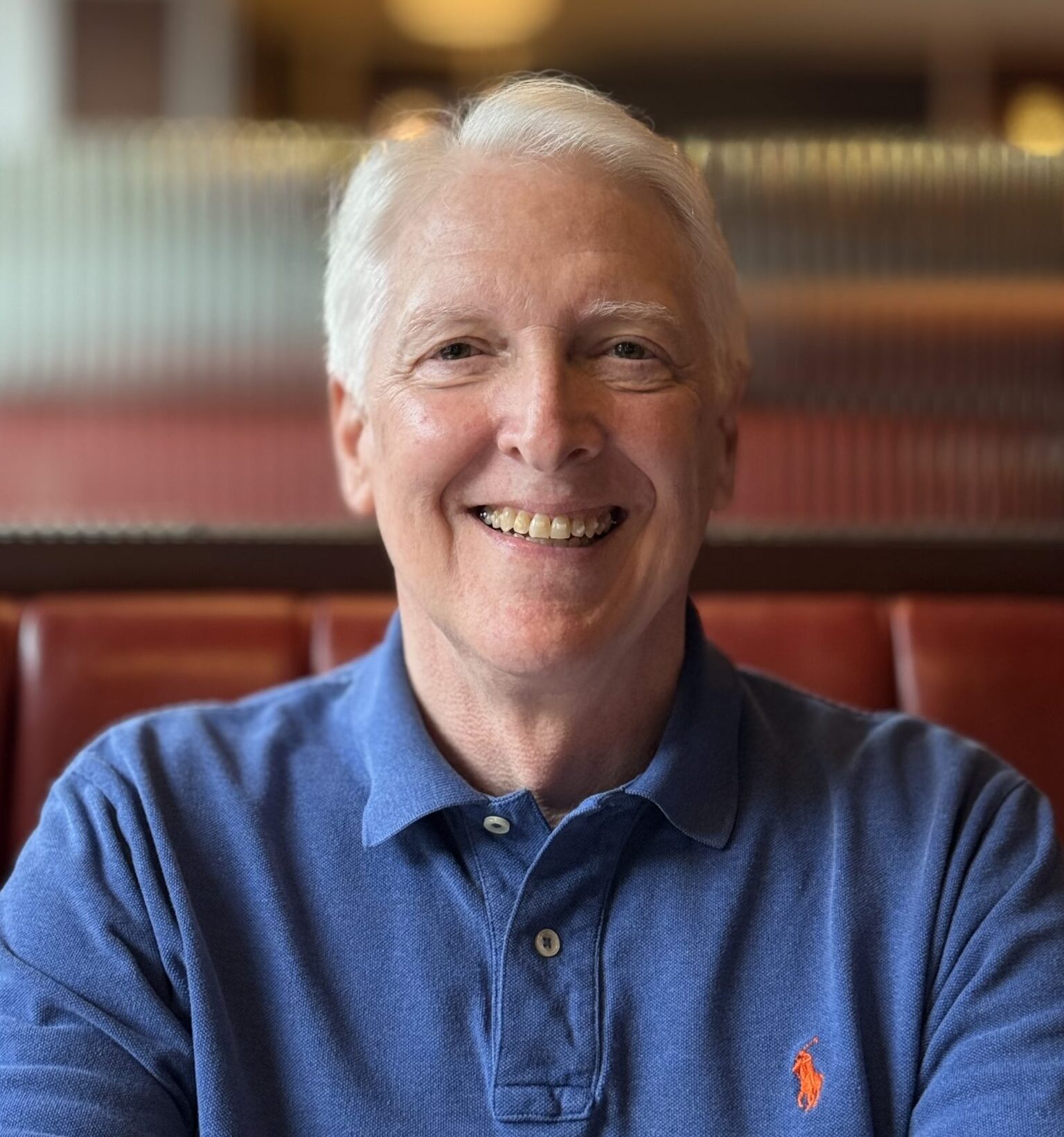 Dr. Hagerty in a blue polo in a diner seat